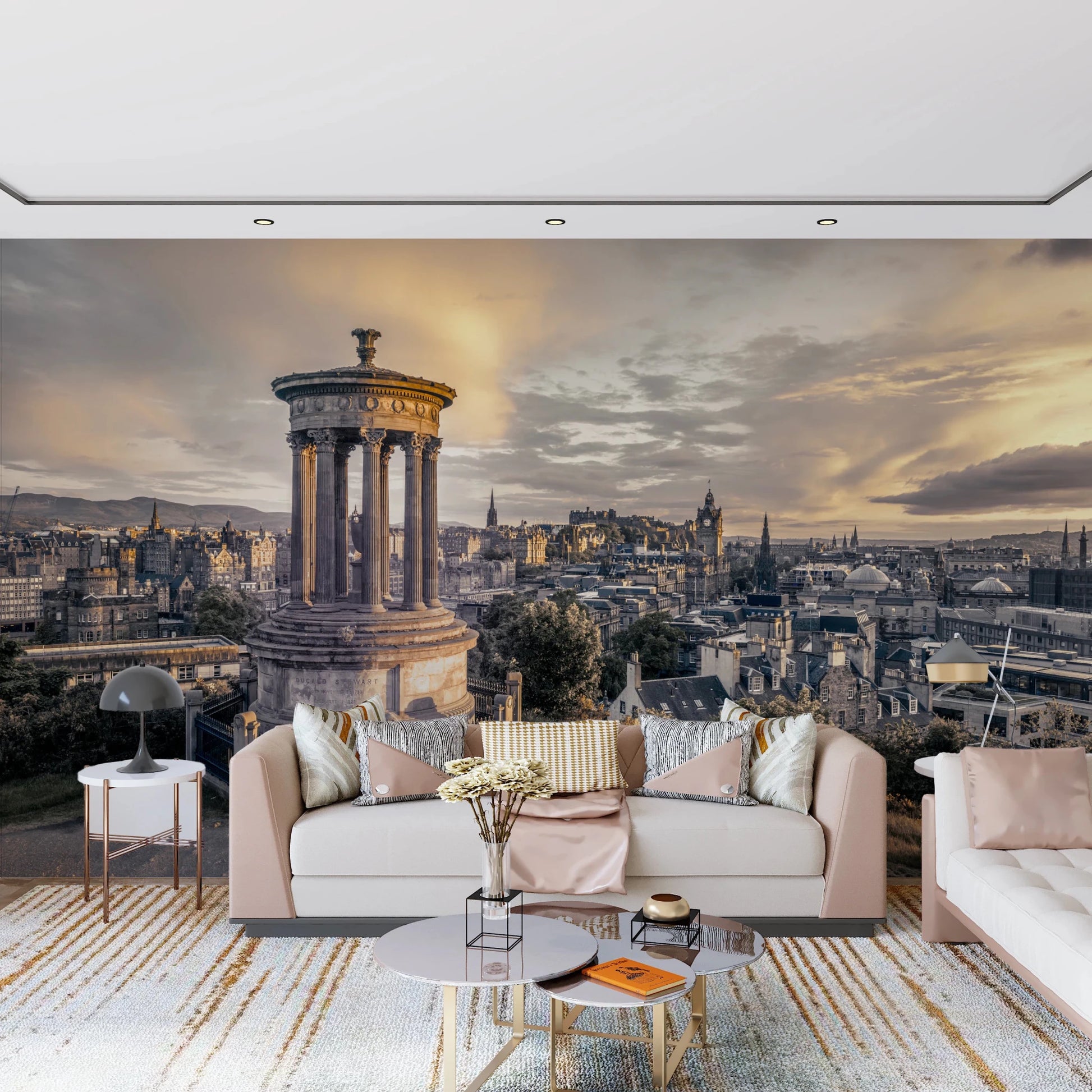 Scottish Skyline wallpaper mural of Edinburgh at sunset behind a blush sofa with round marble tables