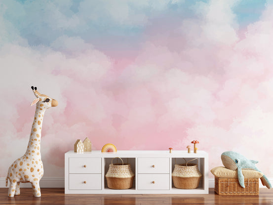 Serene Cotton Candy Horizon wallpaper mural in pink and blue clouds behind a plush giraffe and sideboard in a nursery