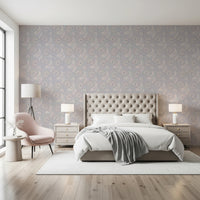 Serene Floral beige wallpaper behind a tufted cream headboard with a pink accent chair in a bright bedroom