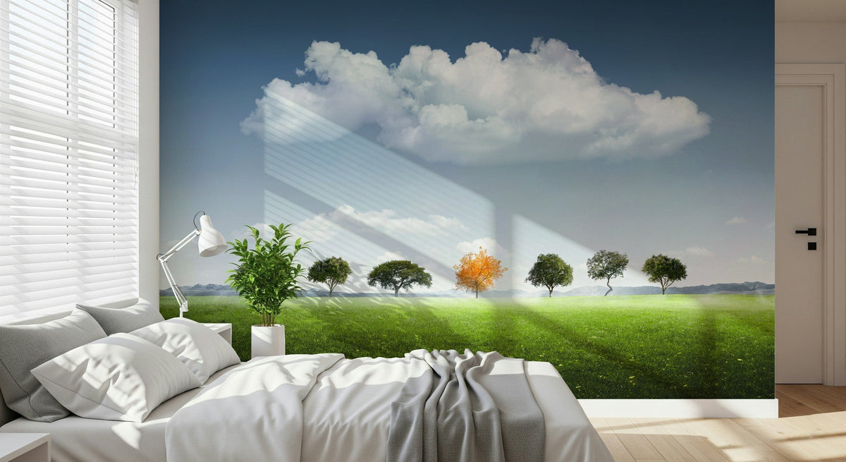Standing Out wallpaper mural of a tree row with one orange tree on a green meadow above a white bed in a bedroom