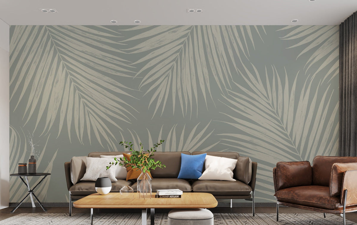 Serenity Palm Whispers wallpaper with cream palm fronds on a sage wall behind a brown sofa in a living room