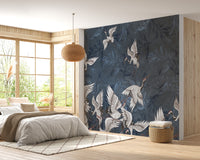 Cranes Grunge wallpaper mural in navy blue with white cranes behind a bed and rattan pendant in a sunlit bedroom