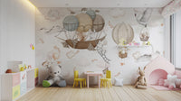 Cloud-Hopping Critters wallpaper mural in beige balloon clouds behind a teddy bear and yellow chairs in a playroom