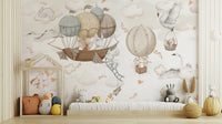 Cloud-Hopping Critters wallpaper mural of bunnies in hot-air balloons above a low daybed and toys in a nursery