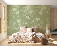 Green Floral wallpaper mural shown as gray birch trees with yellow leaves behind a white fireplace and rattan chair