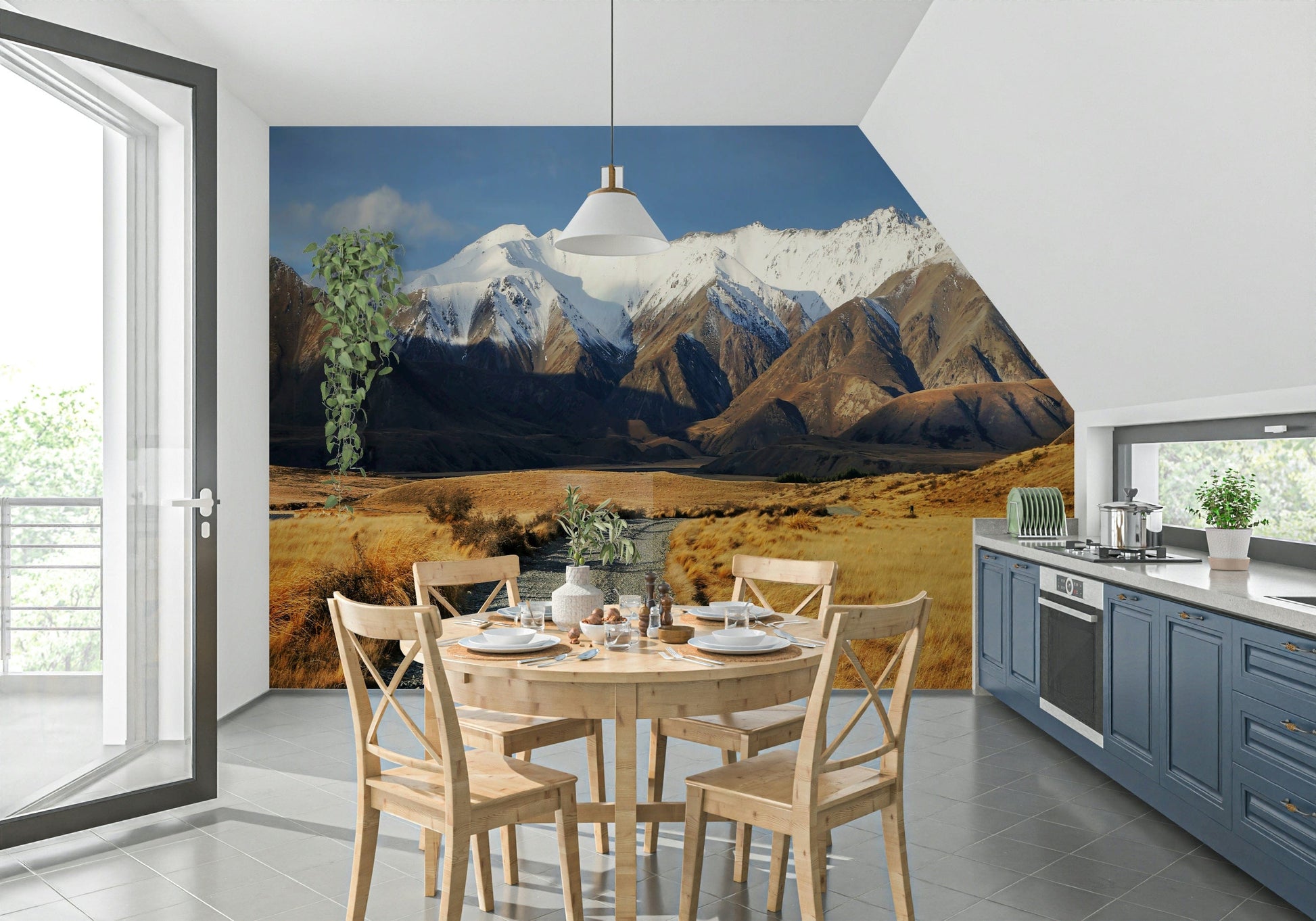 Snowy Peaks Path wallpaper mural of snowy mountains and golden valley behind a round wood table in a kitchen diner