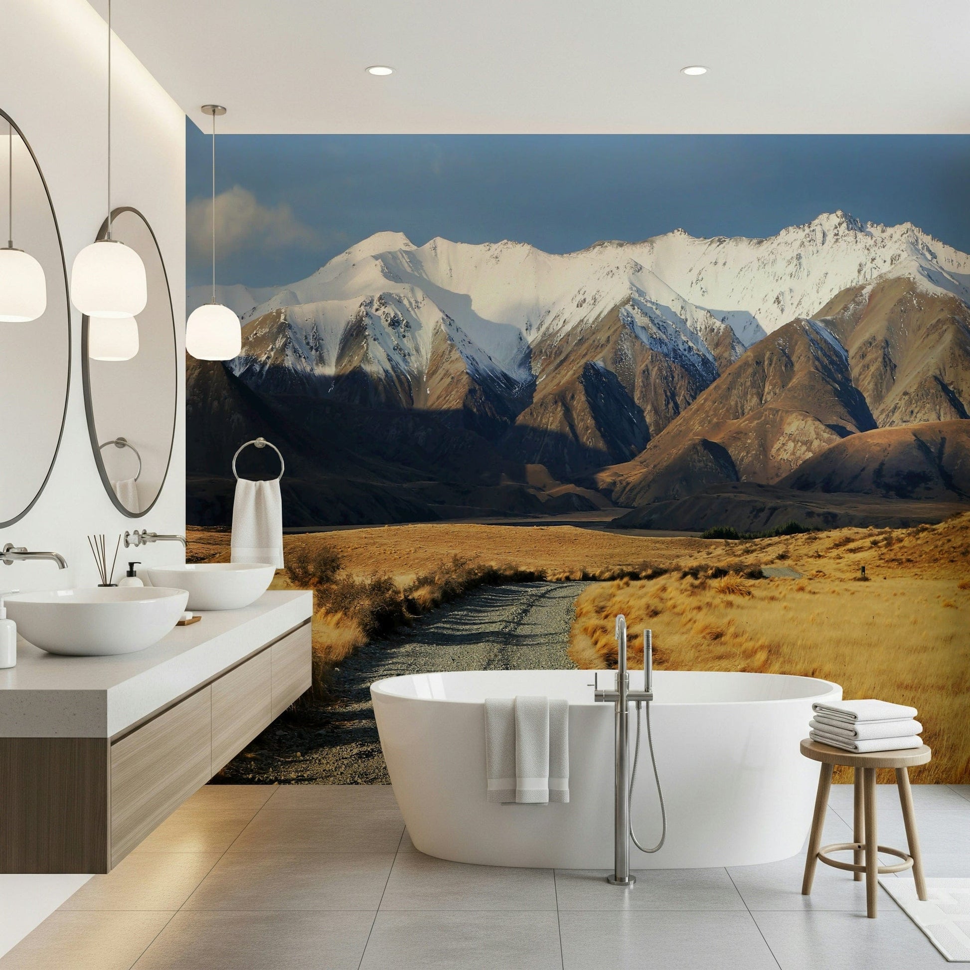 Snowy Peaks Path wallpaper mural of snowy peaks and a gravel path behind a freestanding tub and double-sink vanity