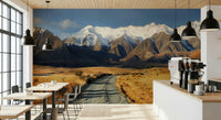 Snowy Peaks Path wallpaper mural of snowy mountains and a gravel path on a cafe wall with wood tables and pendants