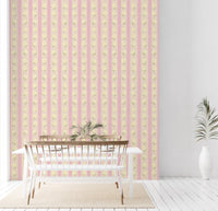 Soft Bloom Stripes wallpaper mural in a dining room behind a white table and bench, pink stripes with yellow flowers