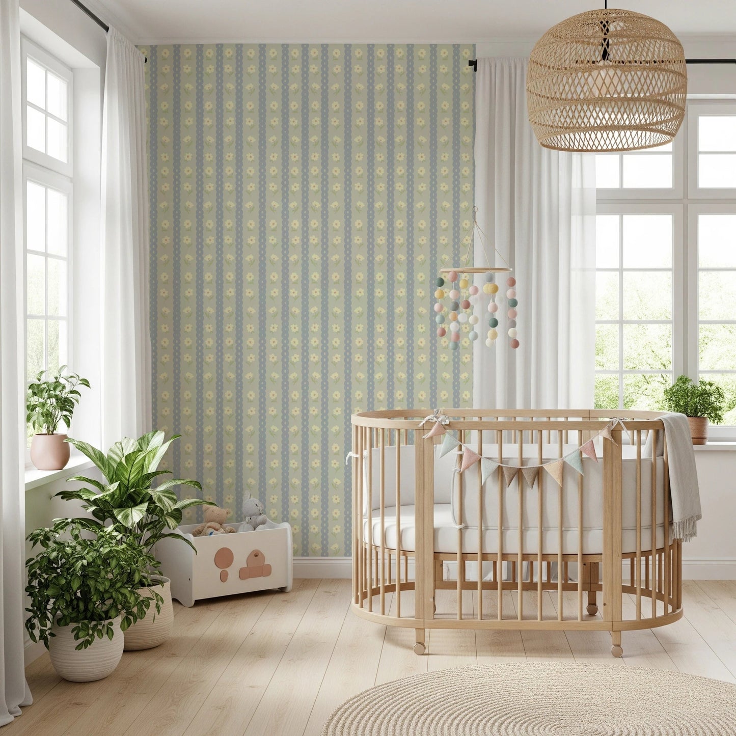 Soft Daisy Stripes wallpaper in green and blue daisy stripes behind a wood oval crib and bunting in a bright nursery