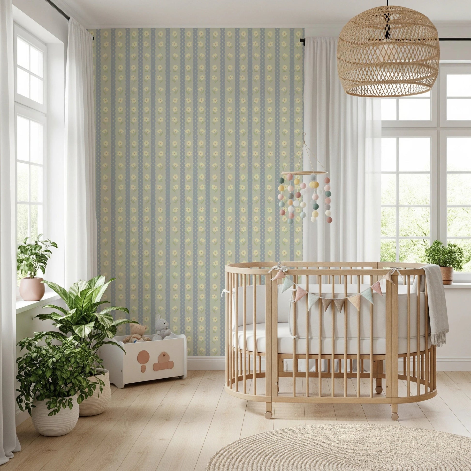 Soft Daisy Stripes wallpaper in green and blue daisy stripes behind a wood oval crib and bunting in a bright nursery