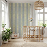 Soft Daisy Stripes wallpaper in green and blue daisy stripes behind a wood oval crib and bunting in a bright nursery