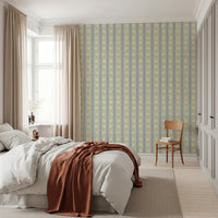 Soft Daisy Stripes wallpaper in green and blue daisy stripes above a white bed with rust throw in a bedroom