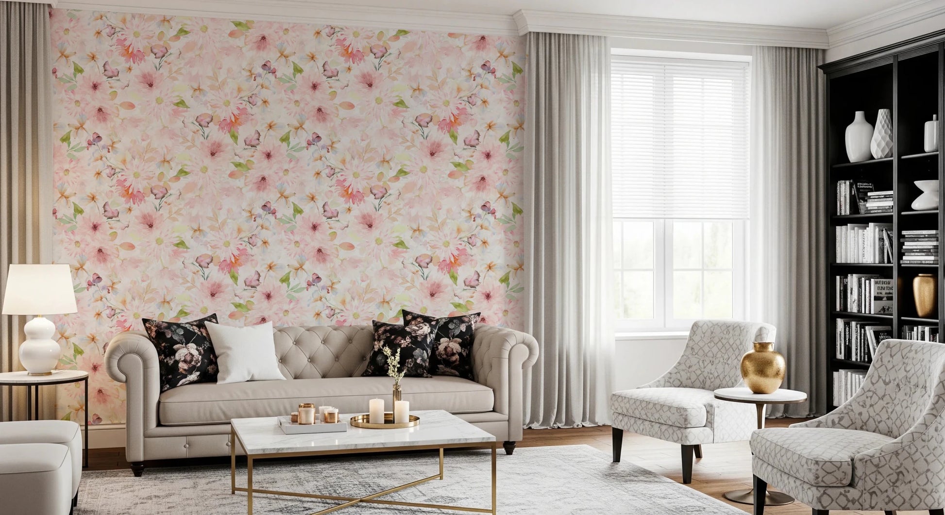 Soft Floral Pink Meadow wallpaper mural in pink florals behind a beige Chesterfield sofa and black bookshelf in a living room
