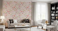 Soft Floral Pink Meadow wallpaper mural in pink florals behind a beige Chesterfield sofa and black bookshelf in a living room