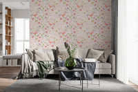 Soft Floral Pink Meadow wallpaper mural of soft pink blooms behind a beige sectional sofa with throws in a living room