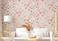Soft Floral Pink Meadow wallpaper mural with watercolor pink daisies behind a white sofa and rattan chairs in a living room