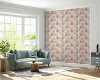 Soft Mosaic Tiles Peach Glow wallpaper behind a teal green sofa and round wood coffee table