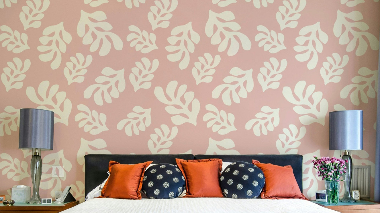 A photo-realistic wall mural with a repeating pattern of soft pink leaves.

