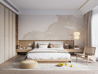 Abstract Watercolor wallpaper mural in soft cream above a wood platform bed with a cane chair in a warm bedroom