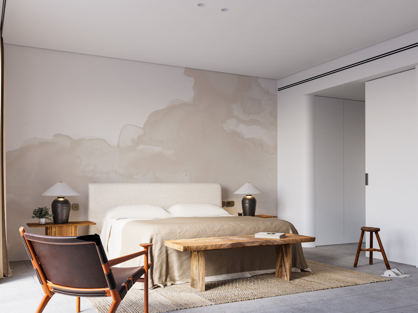 Abstract Watercolor wallpaper mural in beige behind a beige upholstered bed and wood bench in a minimalist bedroom