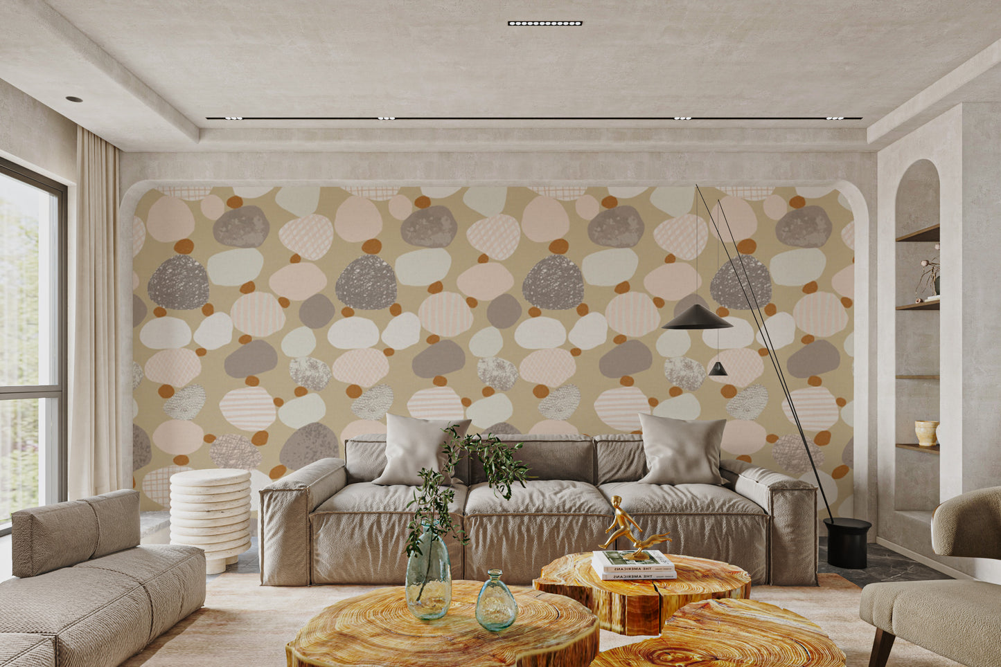Soothing Speckle wallpaper in beige, grey and blush pebble shapes behind a beige sofa in a calm living room