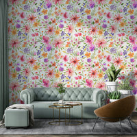 Close-up of colorful dahlias surrounded by soft green foliage and whimsical patterns.

