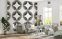 Starburst Deco wallpaper of black starbursts on cream behind a grey sofa with striped cushions and beanbag