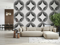 Starburst Deco wallpaper of black sunburst fans on cream behind a cream sectional near a dark dining area
