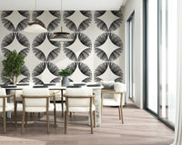 Starburst Deco wallpaper of black starbursts on cream behind a marble dining table with cream chairs