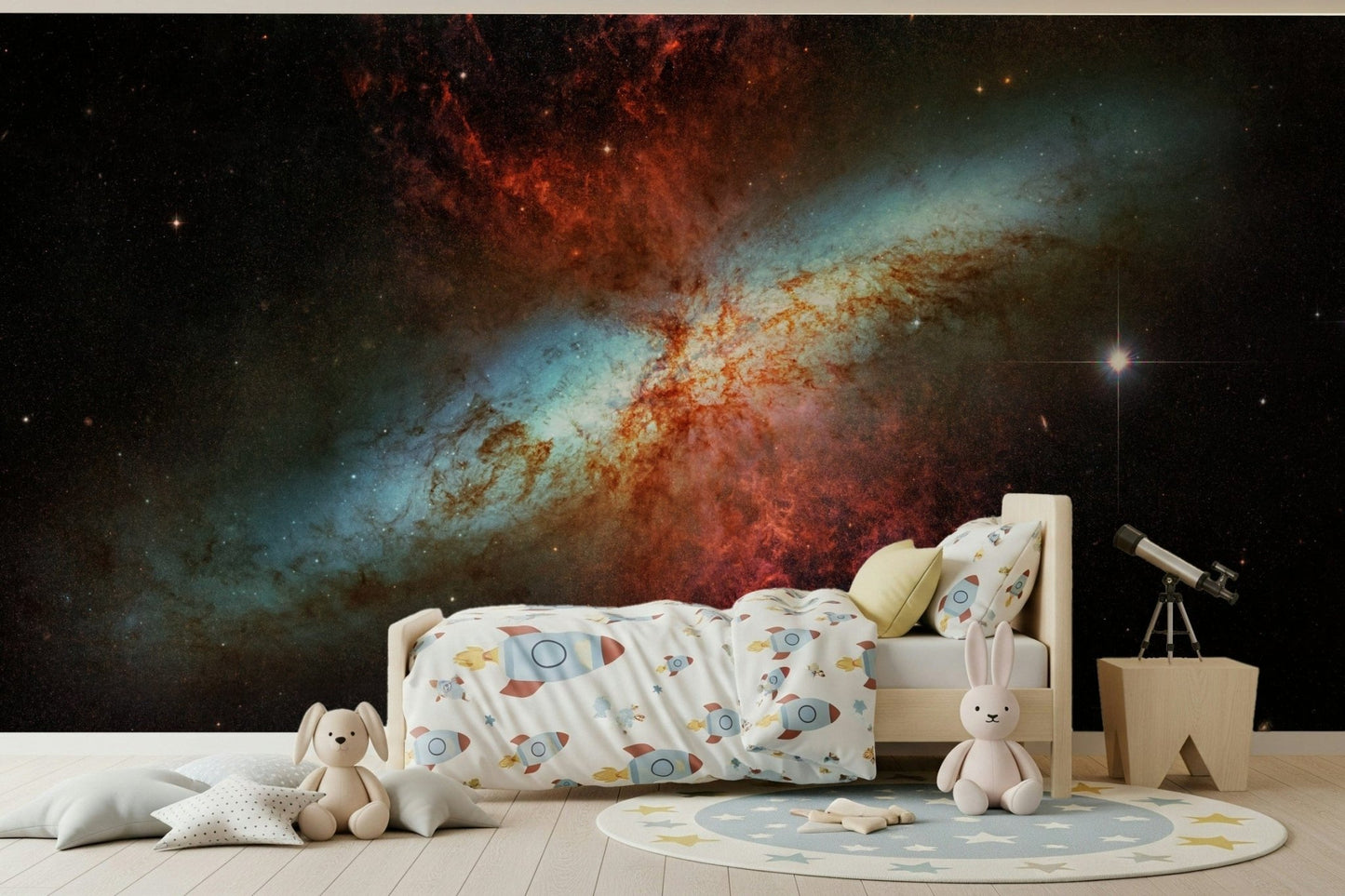 Stardust Symphony wallpaper mural of a fiery starburst galaxy in a kids room with rocket bedding and plush toys