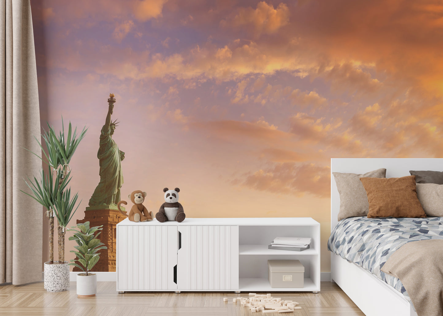 Statue of Liberty wallpaper at orange sunset behind a white console with plush toys in a kids bedroom