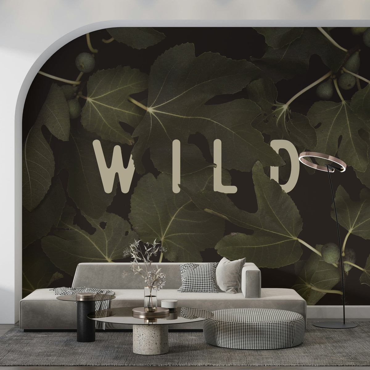 Fig Leaves Stay Wild wallpaper mural with dark olive fig leaves and WILD text beside a curved archway and grey sofa in a living room