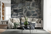 Stone Facade wallpaper mural behind a cream sectional with a green throw and round metal nesting tables