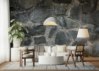Stone Facade wallpaper mural behind a white sofa with a dome pendant, monstera and terrazzo table