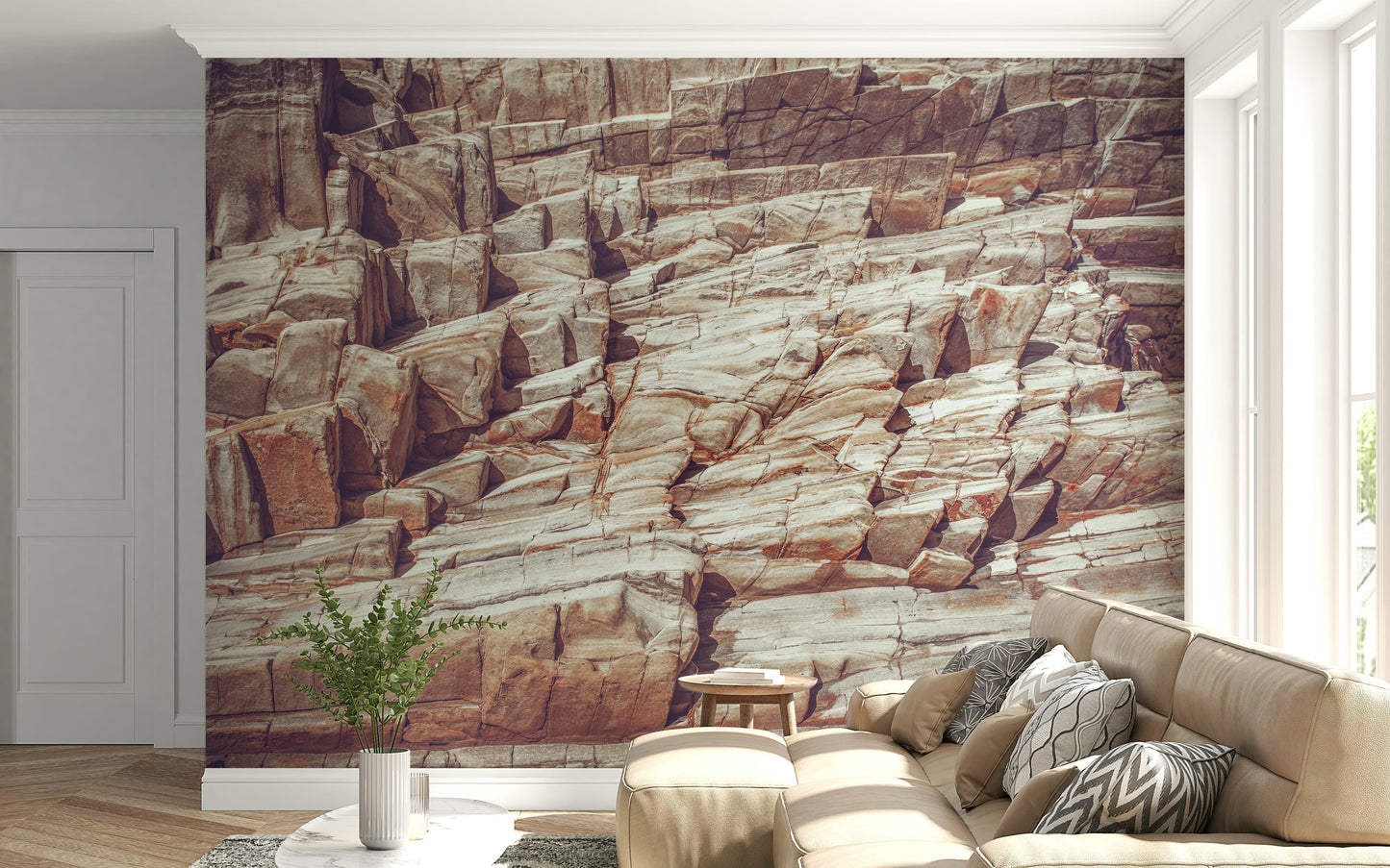 Striated Rock Face wallpaper mural of layered cliff stone behind a tan sectional sofa in a bright living room