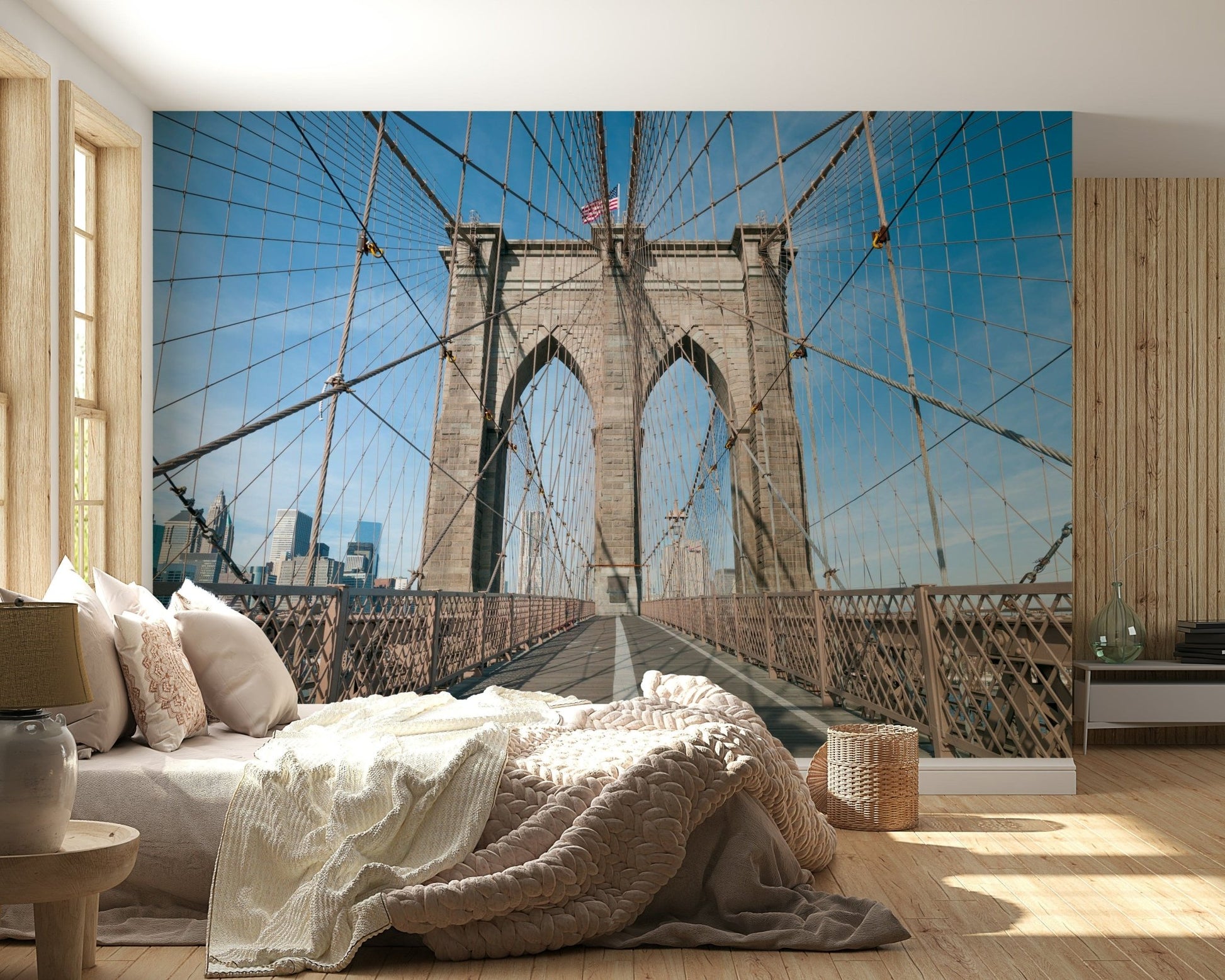 Strolling Across the Brooklyn Bridge wallpaper mural behind a low bed with cream knit bedding in a wood-panelled bedroom