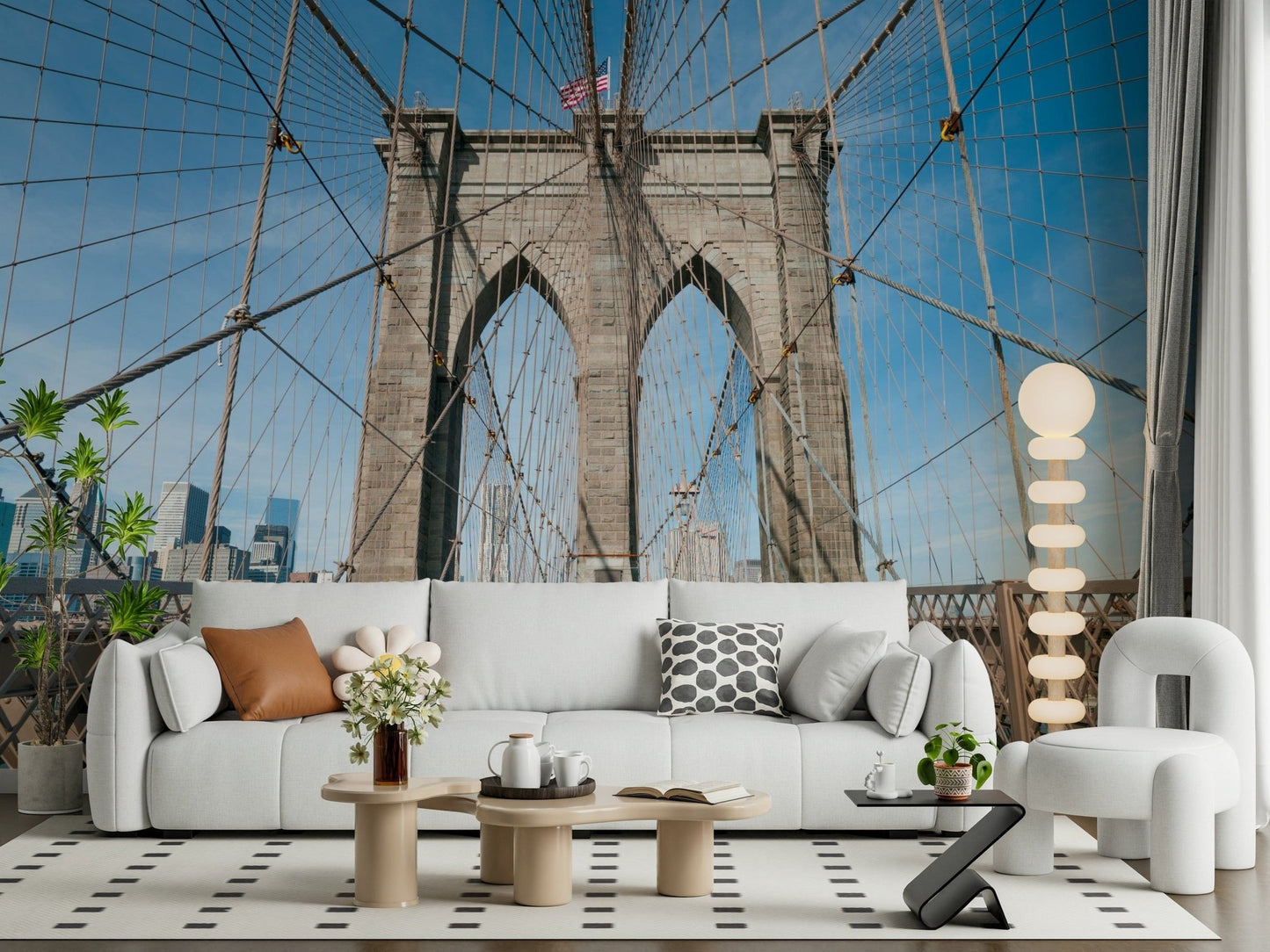 Strolling Across the Brooklyn Bridge wallpaper mural of the cable-strung tower above a white sofa with a tan pillow