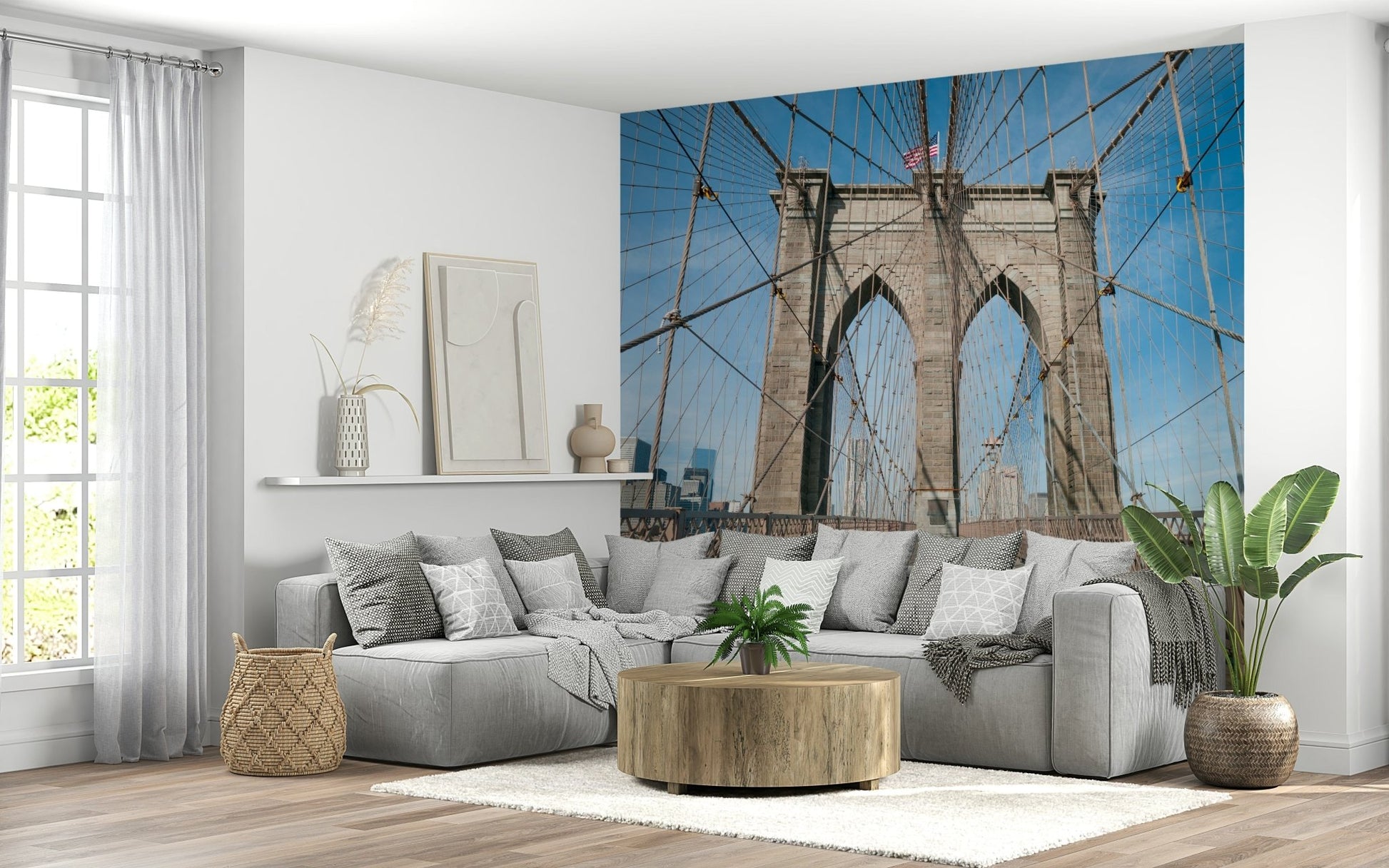 Strolling Across the Brooklyn Bridge wallpaper mural above a grey sectional and round wood table in a living room