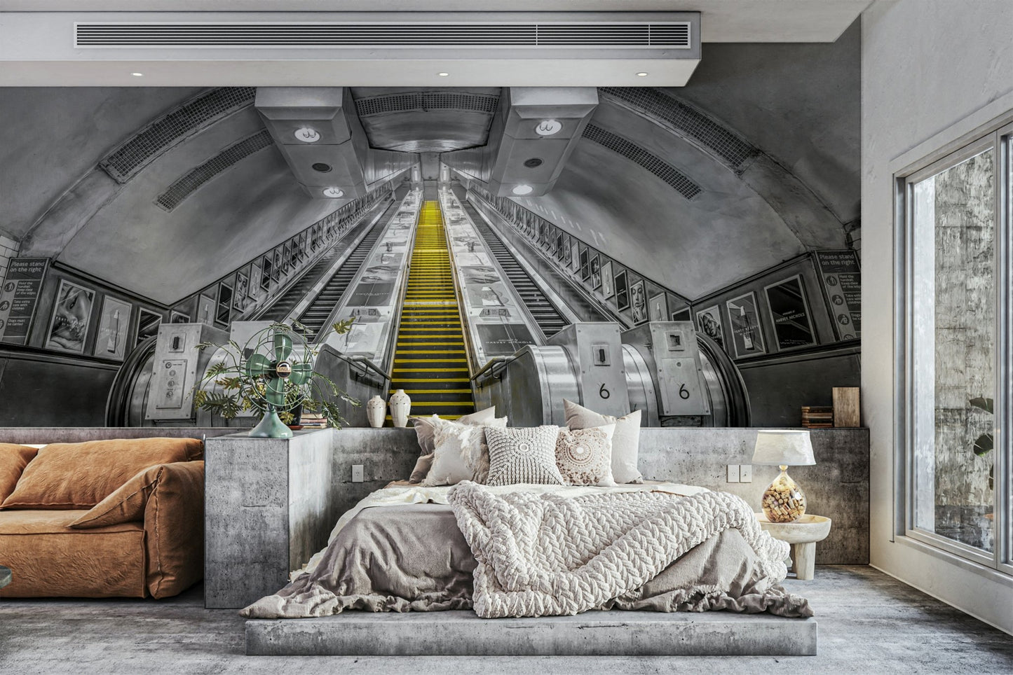 City subway escalator with yellow accents on mural wall

