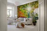 Sun Rays Through Trees wallpaper mural of autumn trees and sunlight in a bright living room with a grey corner sofa