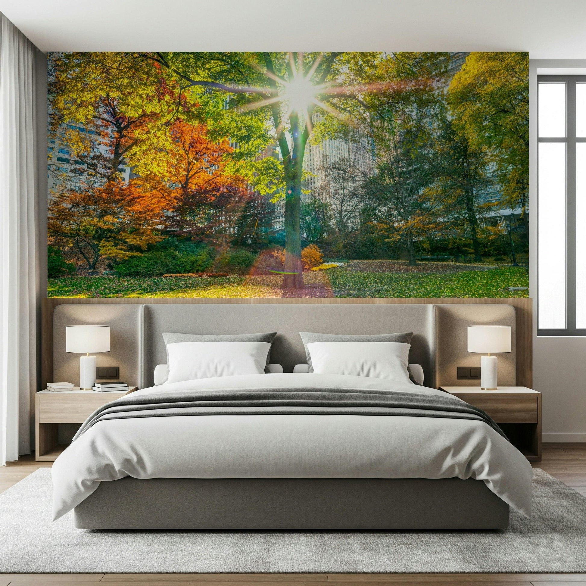 Sun Rays Through Trees wallpaper mural shown as a panoramic park scene above a grey bed with white pillows
