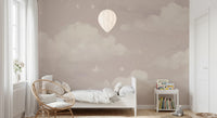 Sweet Dreams Blush wallpaper mural of a blush cloud sky in a kids bedroom with a white bed and rattan chair