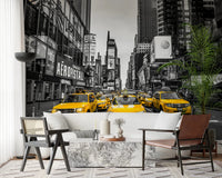 Taxi Rush Hour wallpaper mural showing yellow taxis in New York behind a white sofa and cane chair in a living room