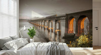 Tay Rail Bridge wallpaper mural with glowing arches over water behind a white bed in a bedroom