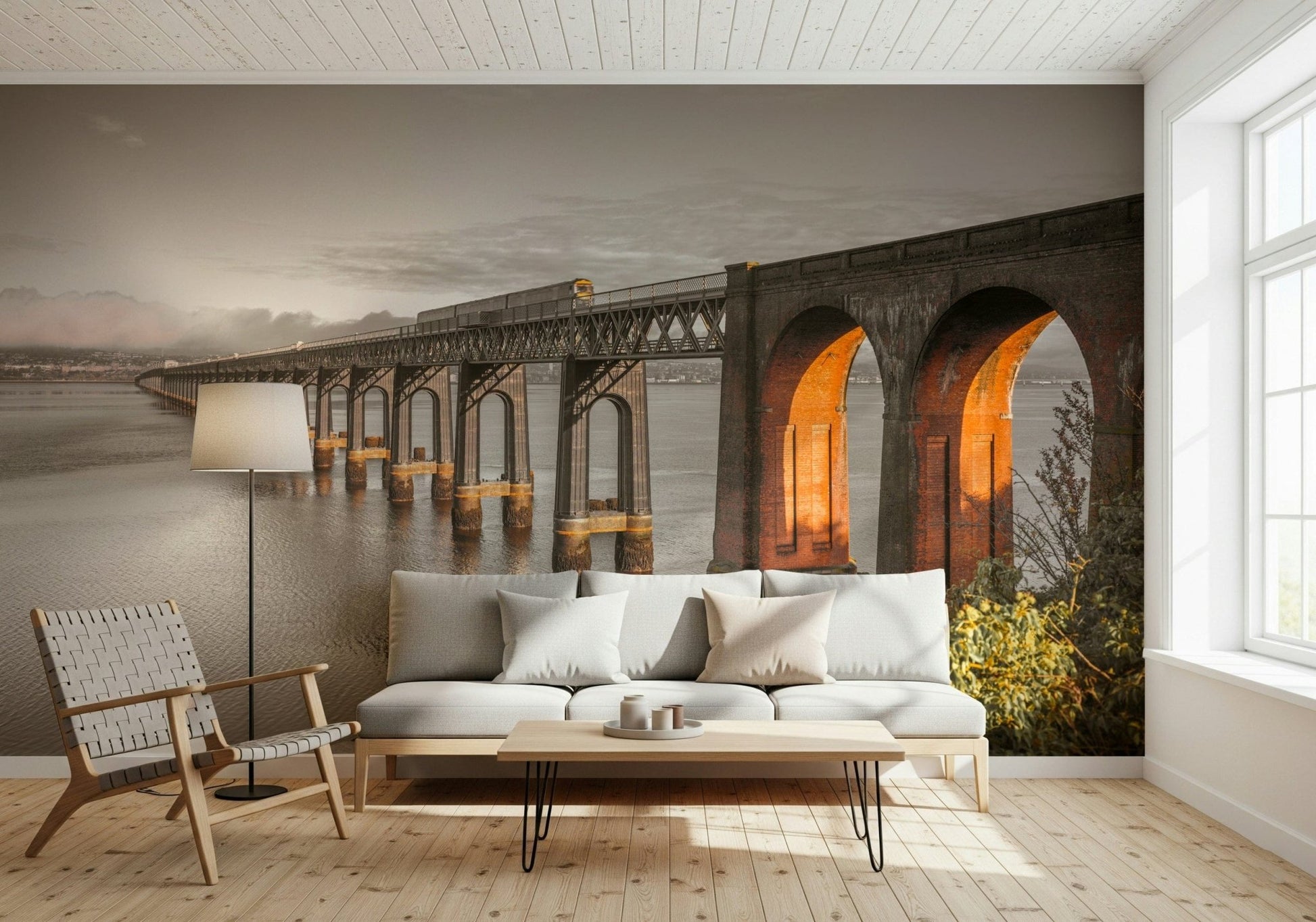 Tay Rail Bridge wallpaper mural in sepia behind a white sofa and woven chair in a living room