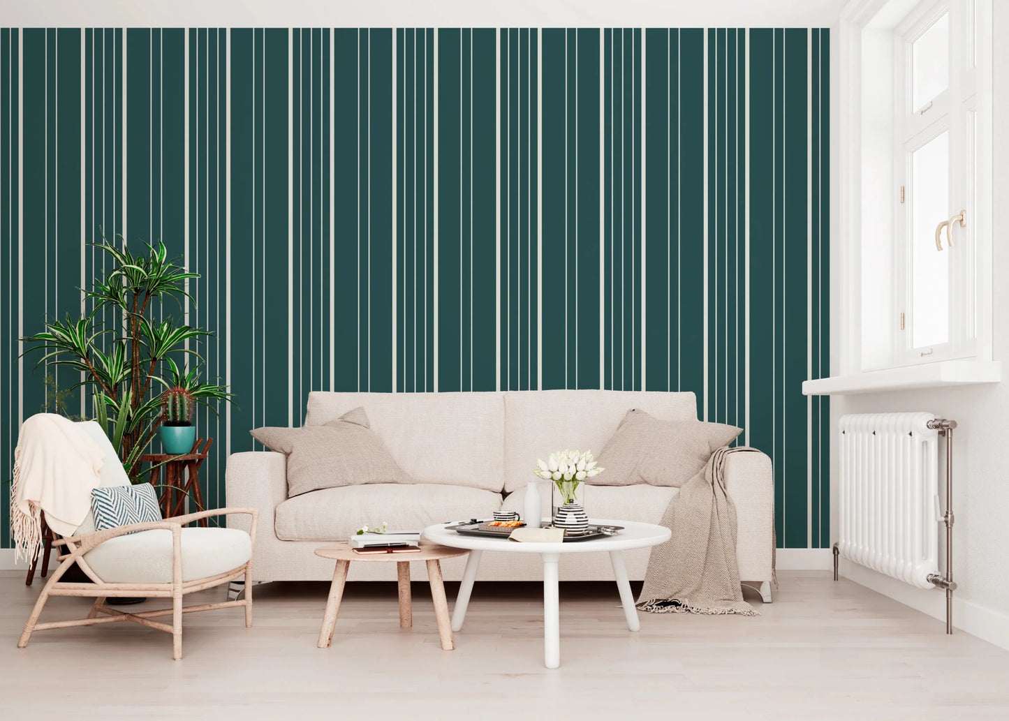 Teal Stripe wallpaper with cream vertical lines behind a beige sofa, rattan chair and leafy plant in a living room