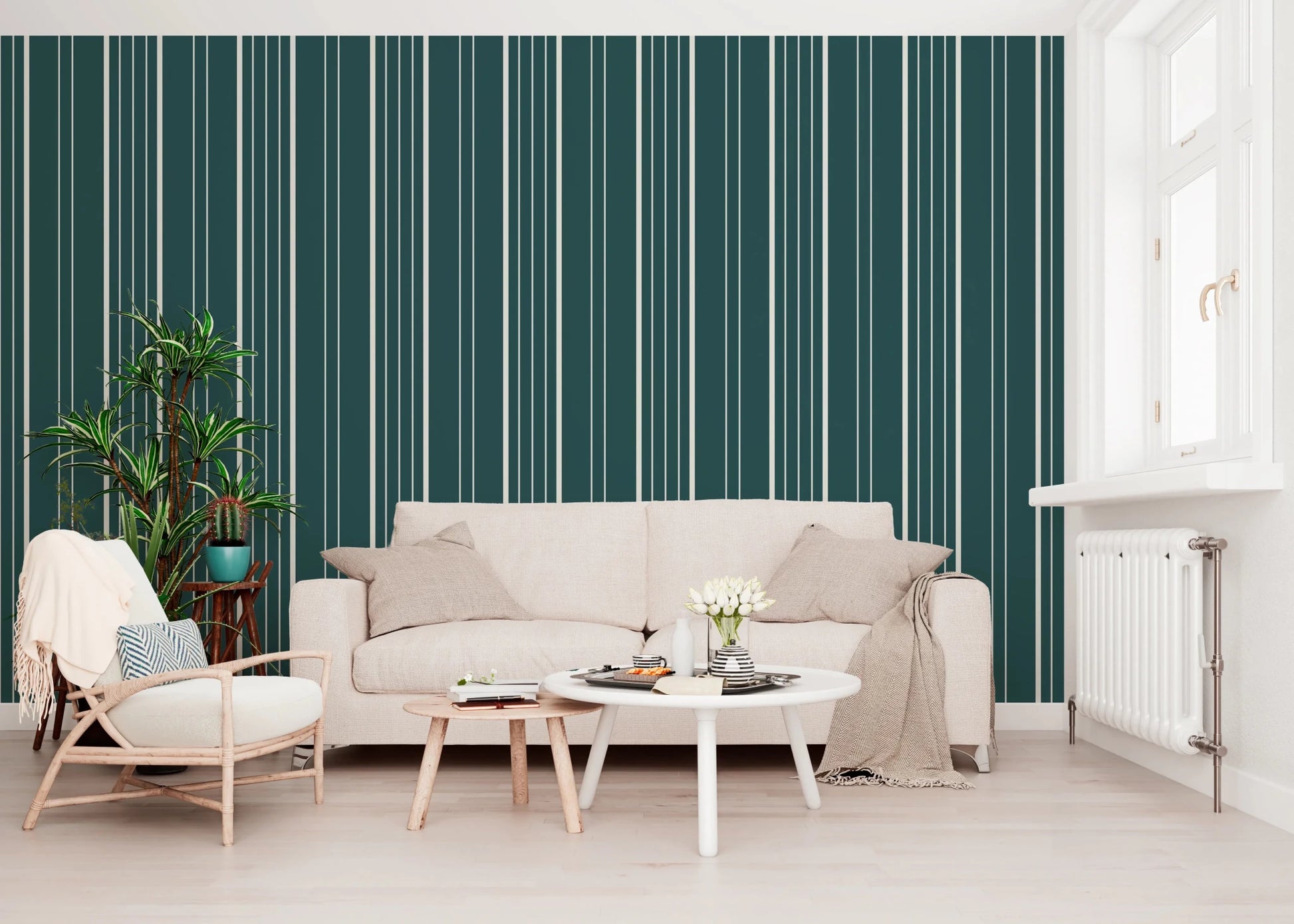 Teal Stripe wallpaper with cream vertical lines behind a beige sofa, rattan chair and leafy plant in a living room