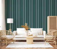 Teal Stripe wallpaper with cream lines behind a white sofa, rattan chairs and pampas grass in a cozy living room