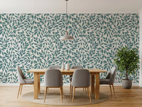 Teal Vines wallpaper with teal foliage behind a wood dining table and grey chairs on a round jute rug